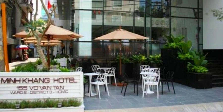 A hotel facade with tables and chairs set up outside, providing a welcoming space for guests to dine al fresco.